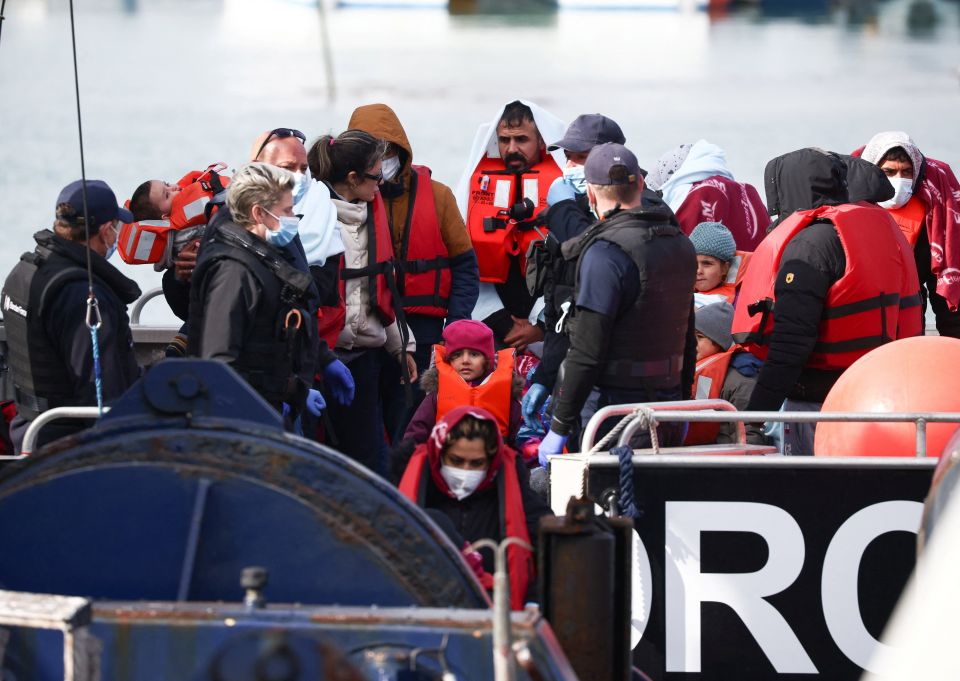 Migrants are escorted by military personnel after being rescued while crossing the English Channel in Dover, England, May 1, 2022. (CNS photo/Henry Nicholls, Reuters)
