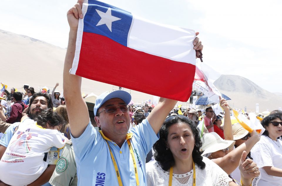 A man holds Chile's flag as people celebrate after attending Pope Francis' celebration of Mass at Lobito beach in Iquique, Chile, in this Jan. 18, 2018, file photo. The pope sent a letter to all dioceses in Chile commemorating the 500th anniversary of the