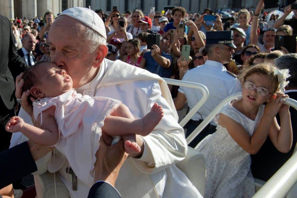 Pope Francis kisses a baby before attending Mass in St. Peter's Square during the World Meeting of Families at the Vatican June 25. The event usually takes place every three years, but it was not held last year because of the COVID-19 pandemic. 