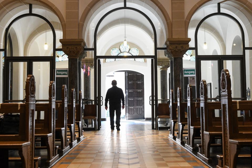 A man leaves an empty church in Bonn Germany, June 12, 2020, during the COVID-19 pandemic. (CNS/Reuters/Harald Oppitz)