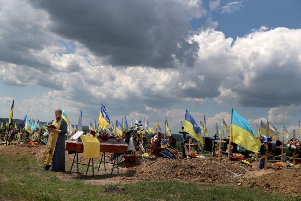 A priest prays during the burial of Evgeny Khrapko, a combat medic and instructor of tactical medicine, in Kharkiv, Ukraine, June 14. Khrapko was killed during the Russian war on Ukraine, which started Feb. 24. (CNS/Reuters/Ivan Alvarado)