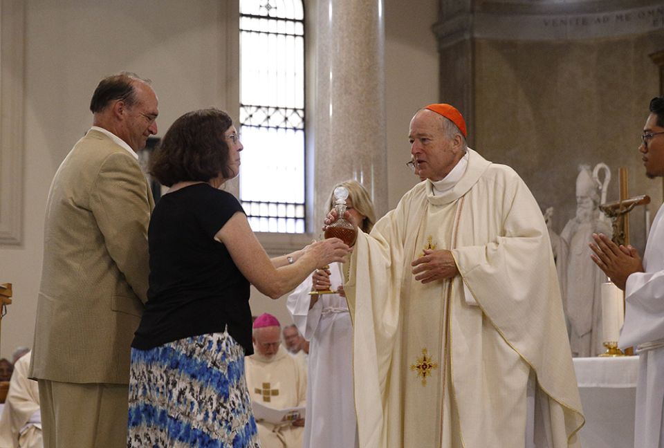 New Cardinal Robert McElroy of San Diego accepts offertory gifts from his sister, Kathy Schreiner, and brother, Walter McElroy, as he celebrates a Mass of thanksgiving at St. Patrick's Church Aug. 28 in Rome. (CNS photo/Paul Haring)