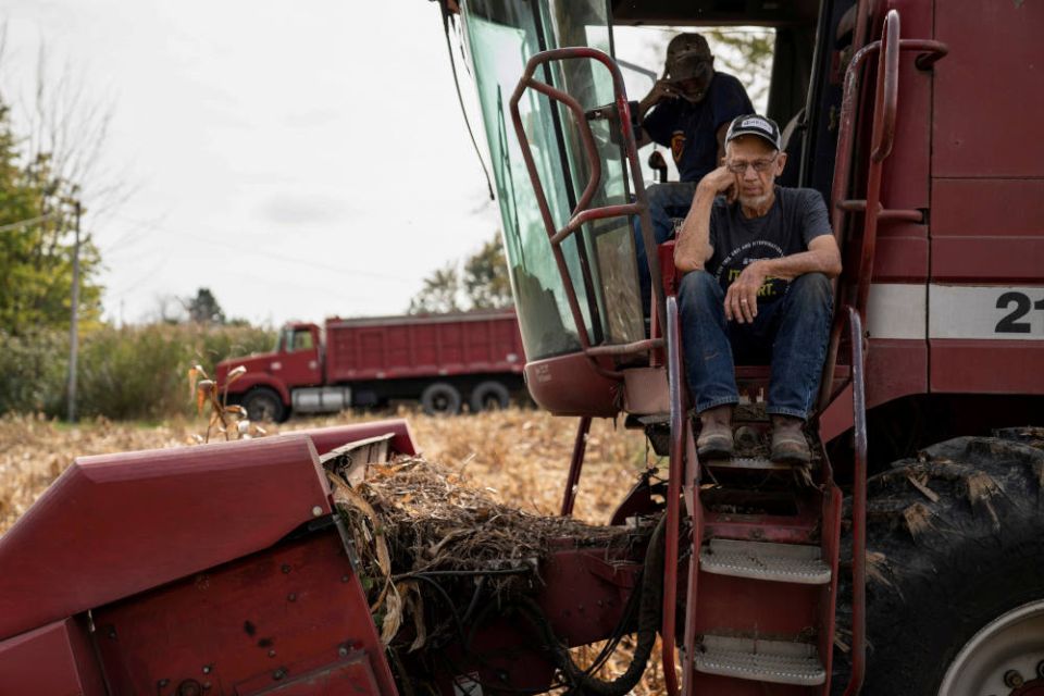 Dale Nething, 86, of Ravenna, Ohio, waits on the steps of his combine Oct. 11, 2021, as his son Don Nething, 62, troubleshoots the harvester after it breaks down. (CNS photo/Dane Rhys, Reuters)