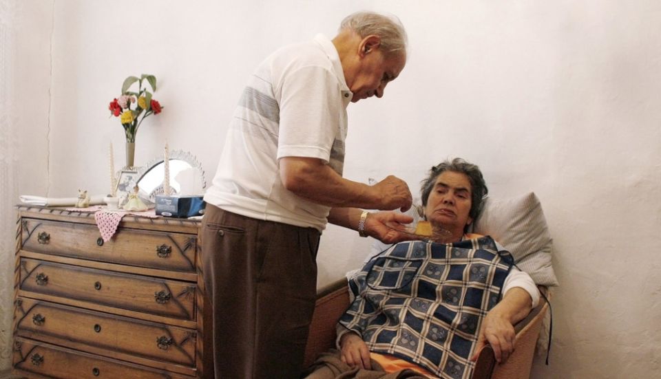 A husband feeds his wife, an Alzheimer's patient, in their house in Lisbon, Portugal, in this 2009, file photo.
